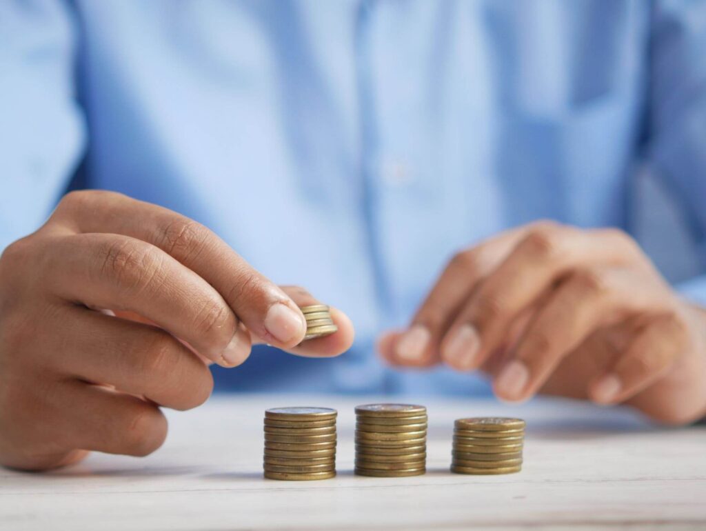 Persona apilando monedas representando los préstamos responsables y la planificación financiera consciente